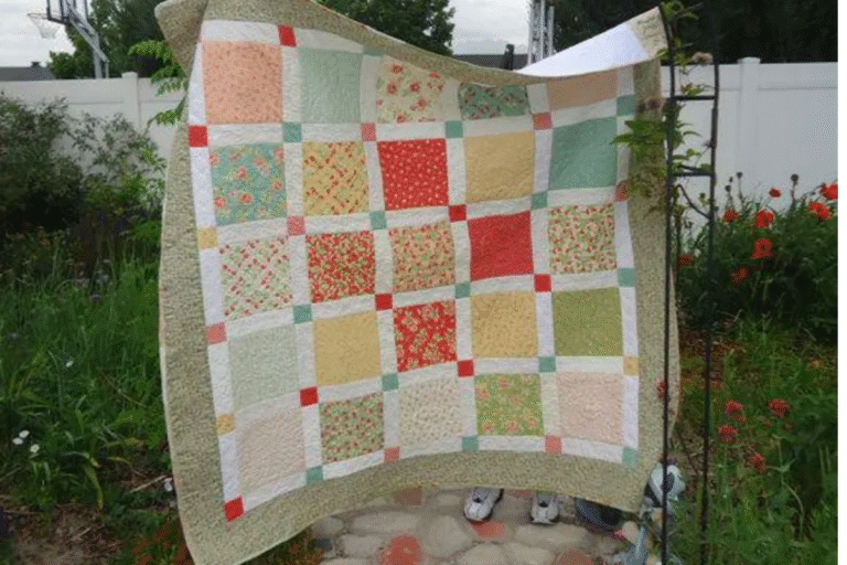 easy layer cake quilt pattern in primary colors and white sashing
